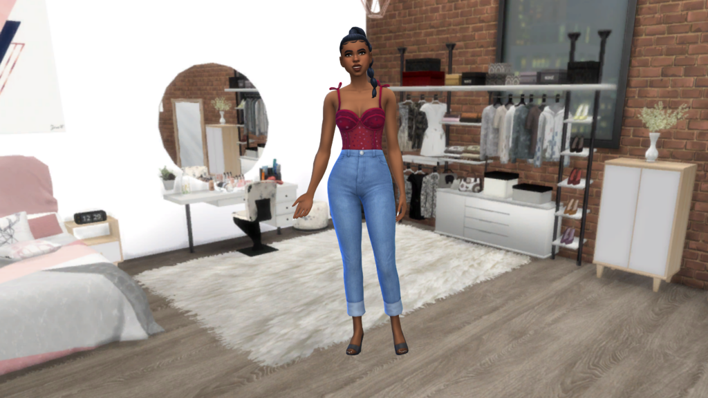 Un sim en jeans taille haute bleus et un body corset rouge avec les cheveux en tresse. Ce sim se tient sur un sol en bois avec un tapis moelleux, dans cette pièce il y a une table de toilette et une commode.