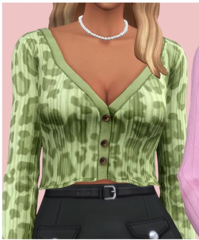 Un sim blond avec la tête coupée de l'image. Il porte un collier de perles avec un cardigan imprimé léopard vert avec les boutons fermés. 