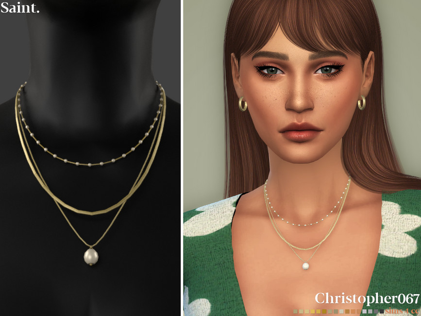 Un Sim aux cheveux bruns avec une frange droite légèrement poussée sur le côté. Il porte un pull vert avec des fleurs blanches et un collier superposé. 