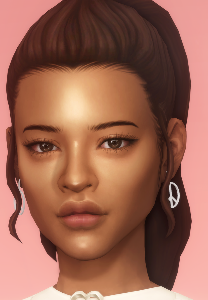 Une image en gros plan d'une sim avec des cheveux bruns et des yeux bruns. Ses cheveux bruns sont attachés en une queue de cheval haute et elle porte une paire de boucles d'oreilles avec un signe de paix.