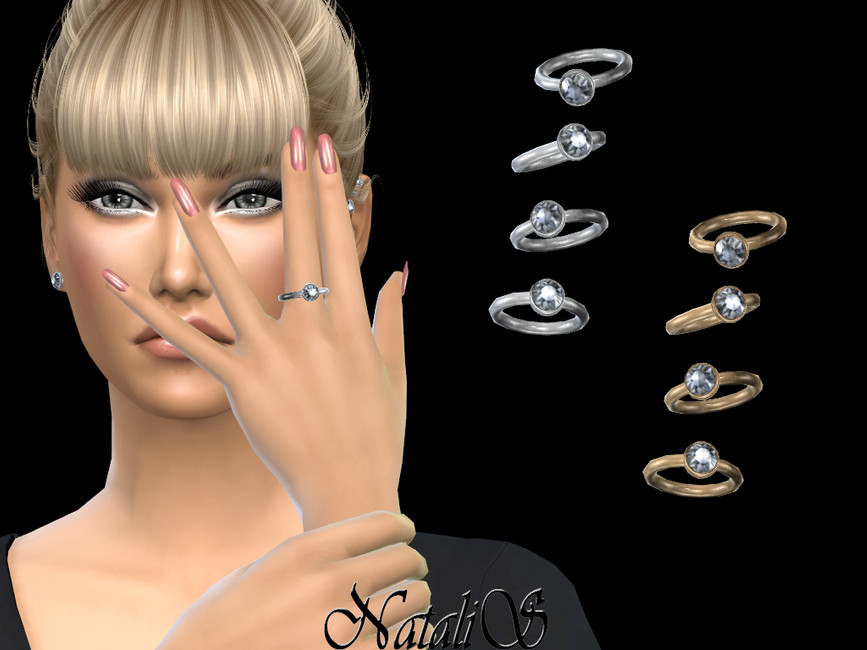 Un Sim aux cheveux blonds attachés en chignon et frange, avec un maquillage des yeux prononcé et des ongles roses. Il porte un t-shirt noir à manches longues et une simple bague en argent pour Les Sims 4, en option pour une bague de mariage.