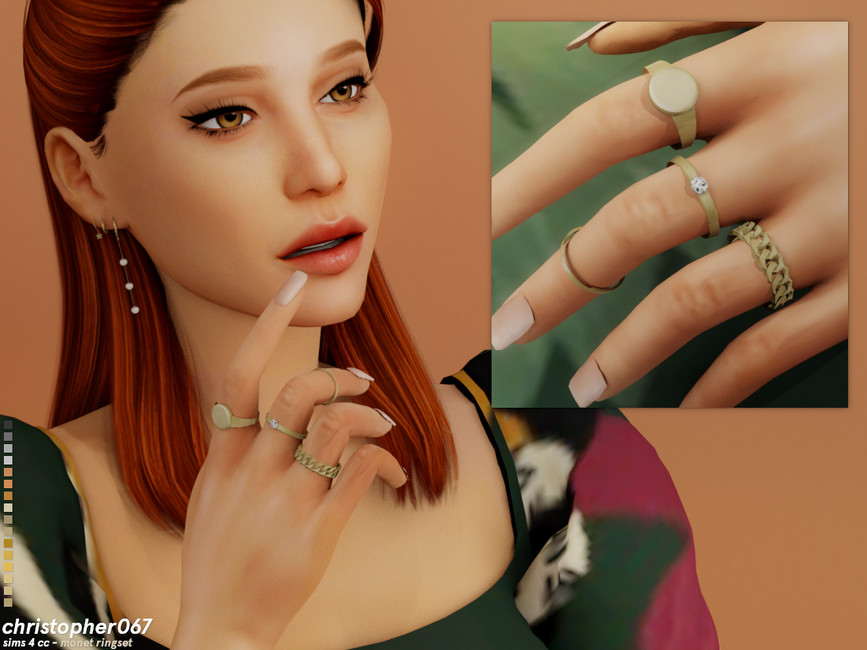 Un Sim aux cheveux roux portant une robe verte à motifs avec de nombreuses bagues sur la main.